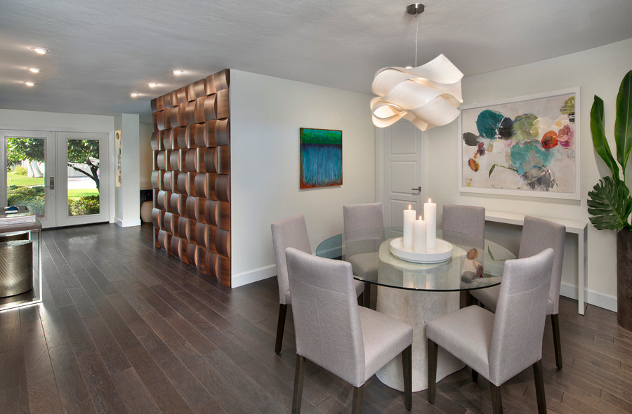 Photo of a medium sized contemporary open plan dining room in Miami with white walls, a standard fireplace, a stone fireplace surround, brown floors and dark hardwood flooring.