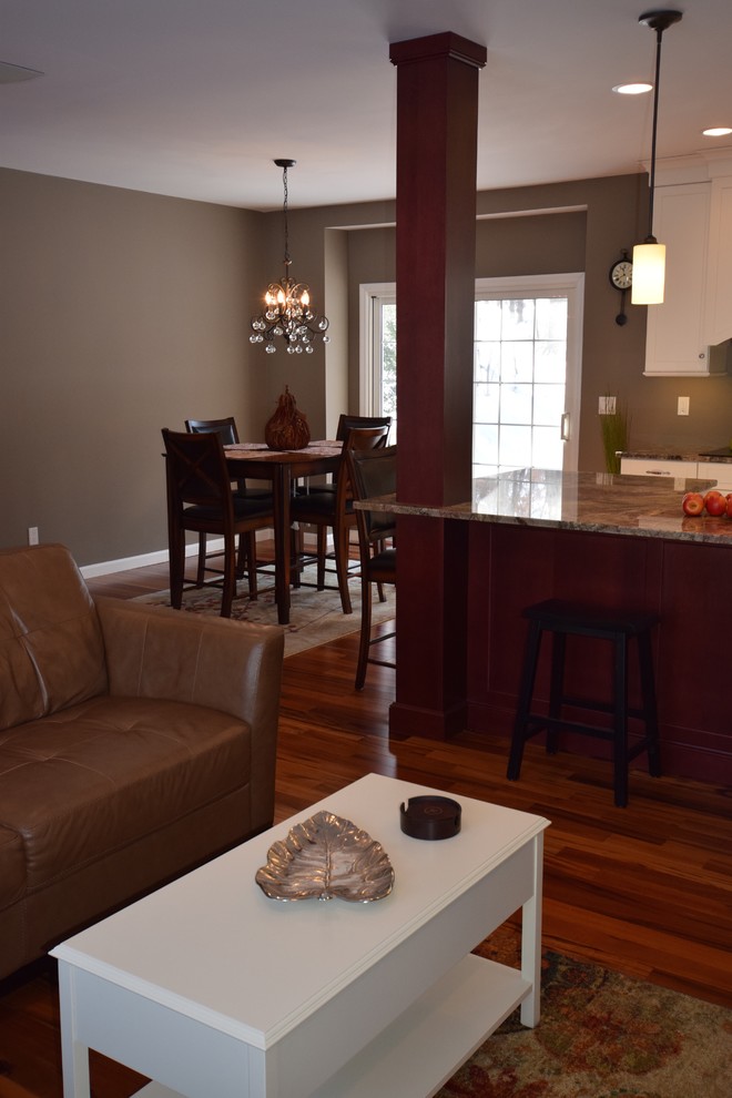Cette image montre une salle à manger ouverte sur le salon traditionnelle de taille moyenne avec un mur marron et parquet foncé.