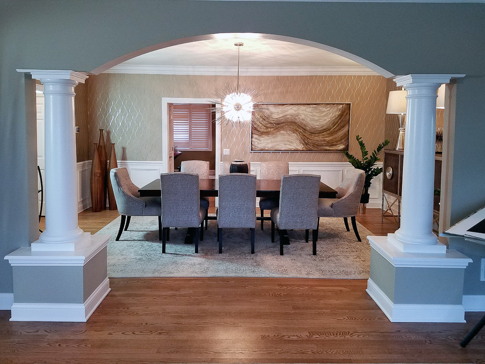Immagine di una sala da pranzo classica chiusa e di medie dimensioni con pareti con effetto metallico, pavimento in legno massello medio e nessun camino