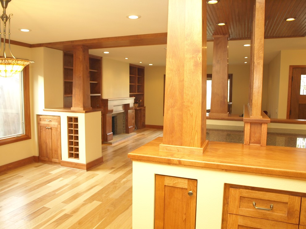 Aménagement d'une salle à manger craftsman avec un sol en bois brun, une cheminée standard et un manteau de cheminée en bois.