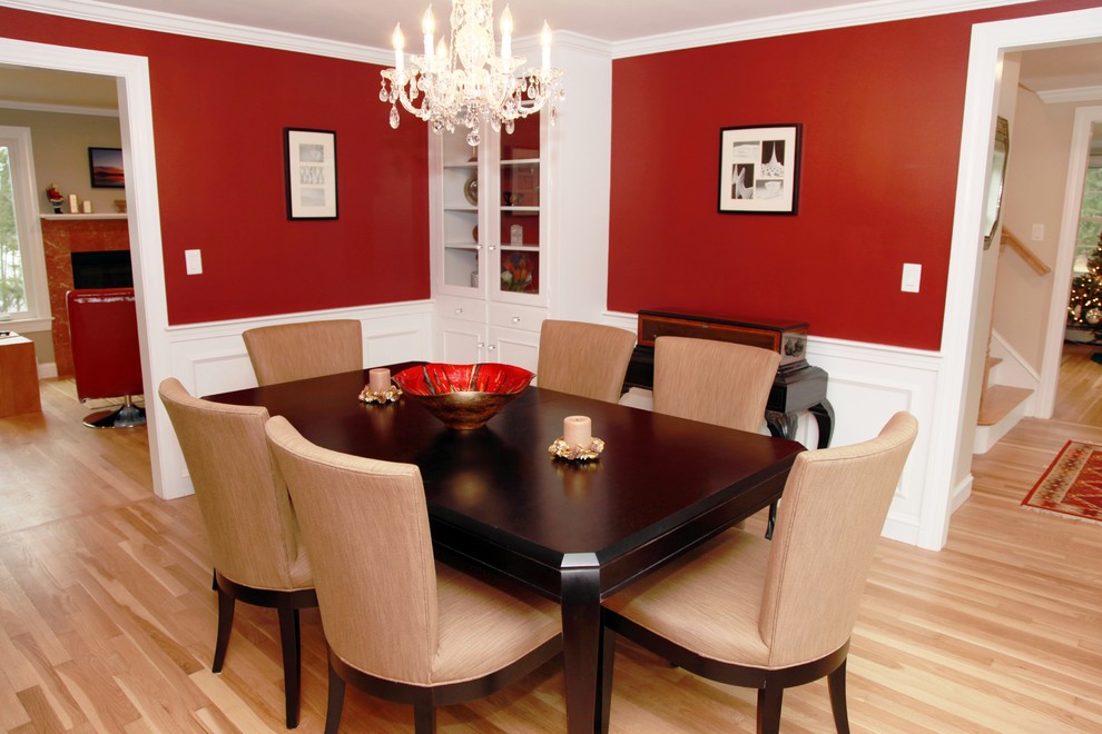Foto di una sala da pranzo chic chiusa e di medie dimensioni con pareti rosse, parquet chiaro e nessun camino