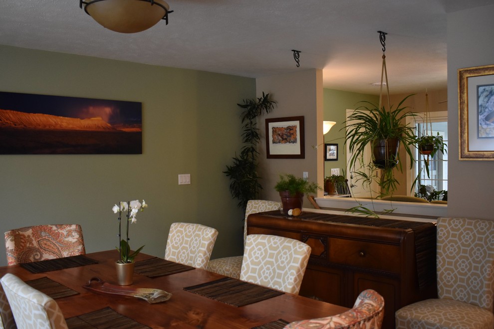 Cette image montre une salle à manger ouverte sur le salon bohème de taille moyenne avec un mur vert, un sol en bois brun, aucune cheminée et un sol marron.