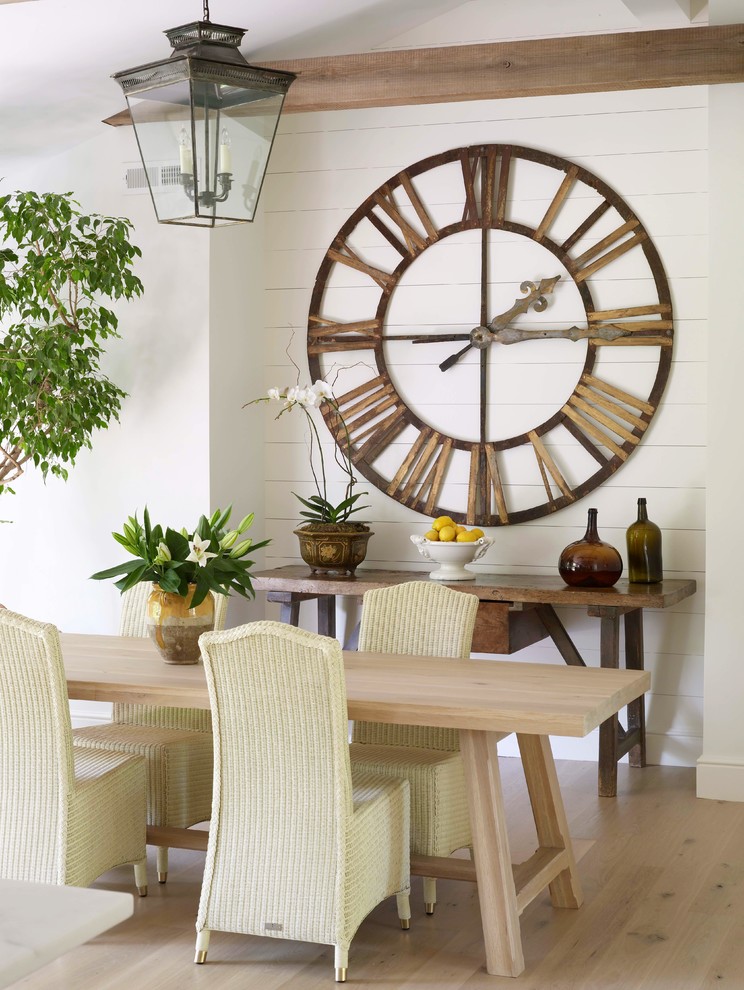 Cette image montre une salle à manger traditionnelle avec un mur blanc et parquet clair.