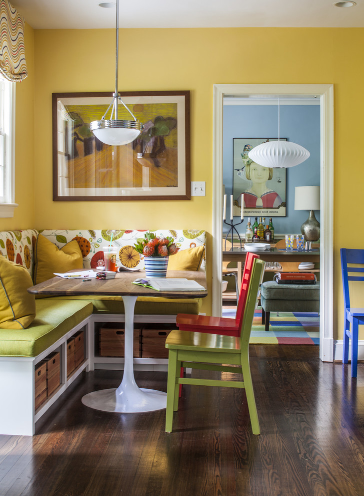 Foto di una sala da pranzo aperta verso la cucina boho chic di medie dimensioni con pareti gialle, parquet scuro e nessun camino