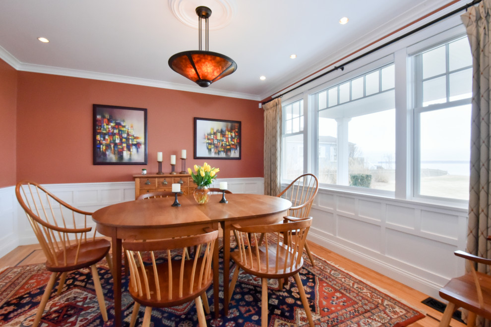 Стильный дизайн: столовая в стиле кантри с оранжевыми стенами, паркетным полом среднего тона, коричневым полом и панелями на стенах - последний тренд