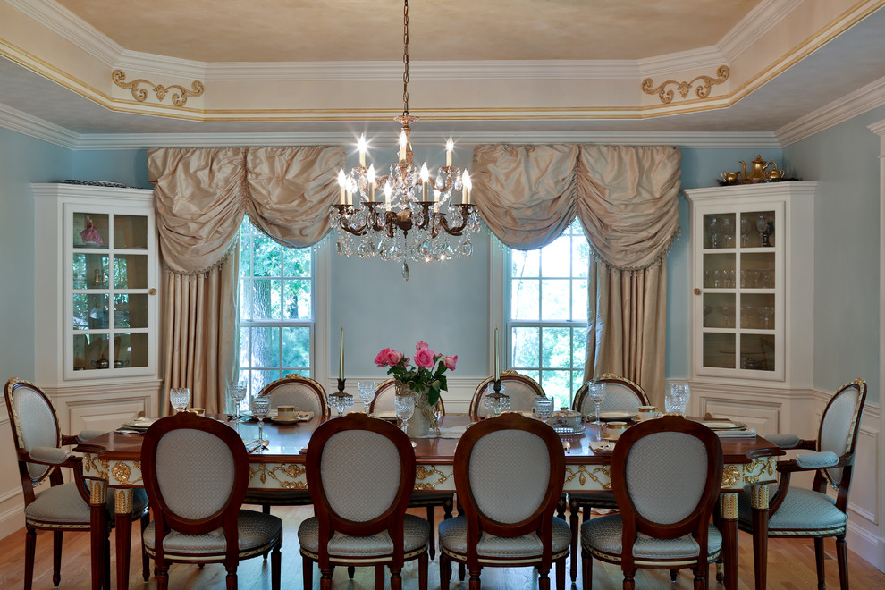 Inspiration pour une grande salle à manger traditionnelle fermée avec un mur bleu, un sol en bois brun et aucune cheminée.