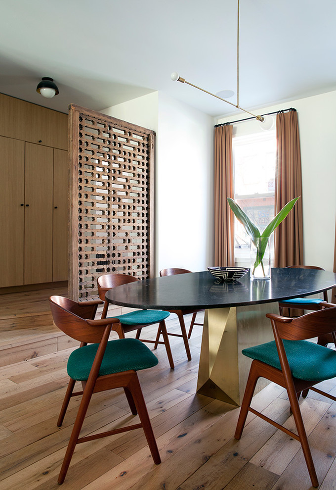 This is an example of a world-inspired dining room in New York with feature lighting.