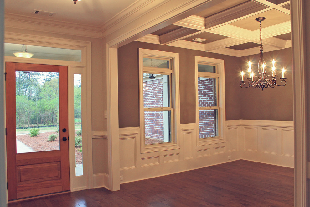 Cette photo montre une salle à manger craftsman fermée et de taille moyenne avec un mur marron et parquet foncé.