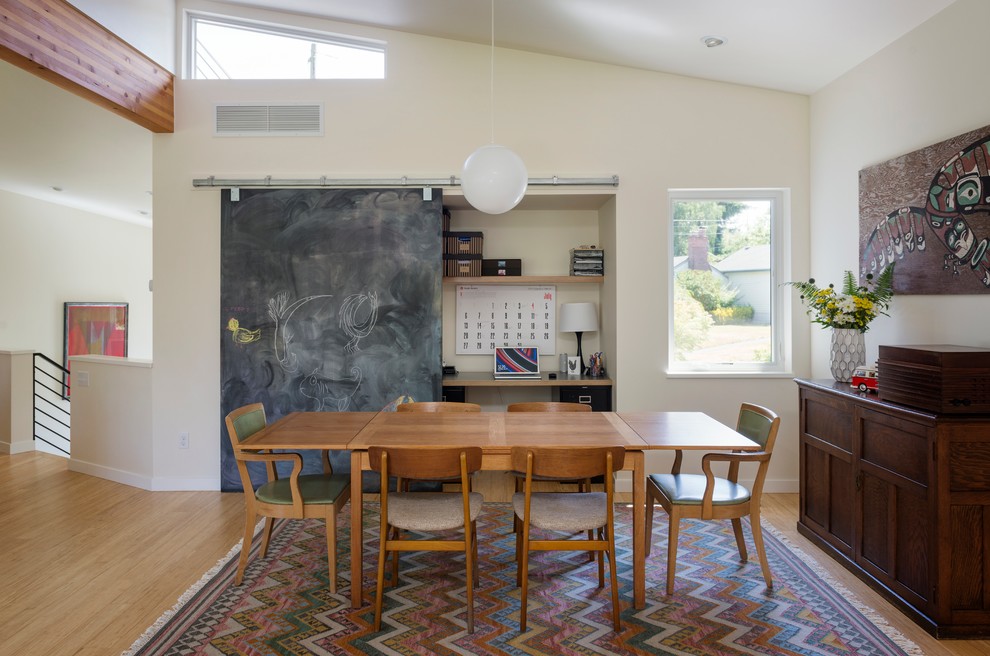 Example of a mid-century modern medium tone wood floor dining room design in Seattle