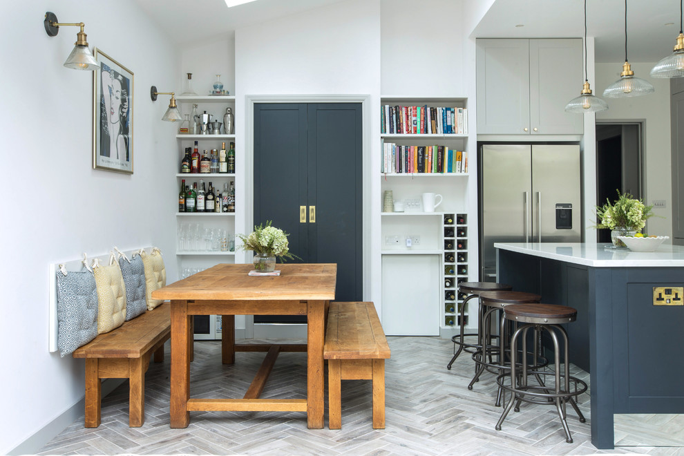 На фото: кухня-столовая в стиле неоклассика (современная классика) с белыми стенами, светлым паркетным полом и серым полом с
