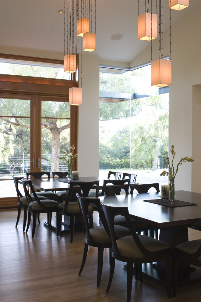 Example of a trendy dark wood floor dining room design in Los Angeles with beige walls