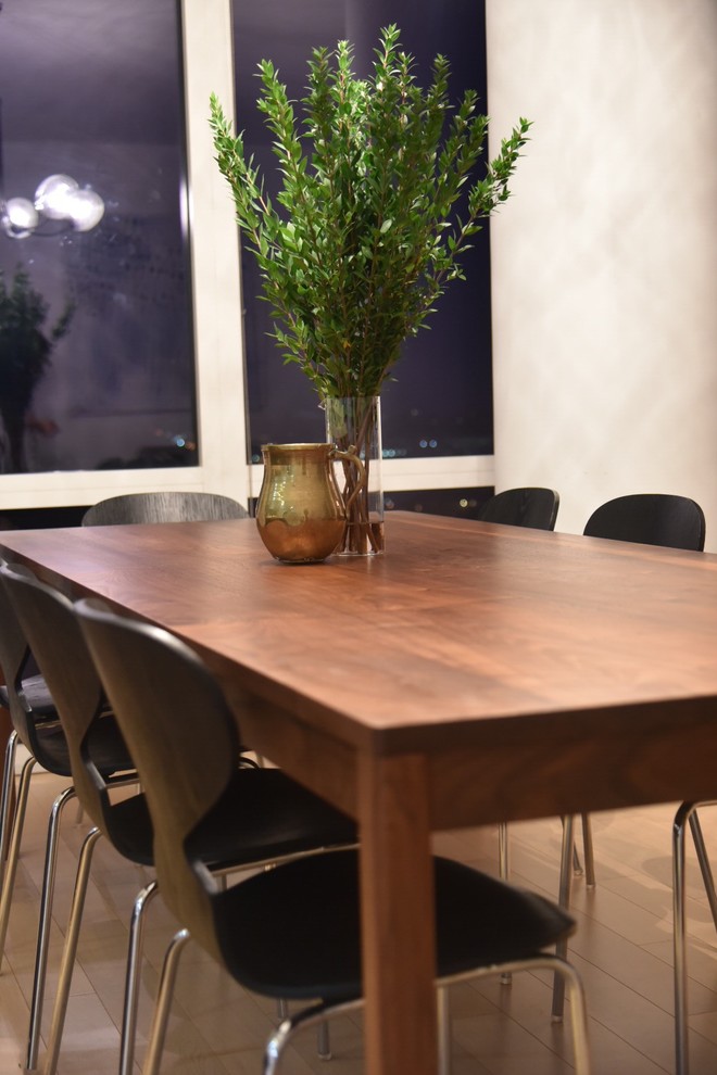 Example of a mid-sized minimalist medium tone wood floor kitchen/dining room combo design in New York with white walls and no fireplace