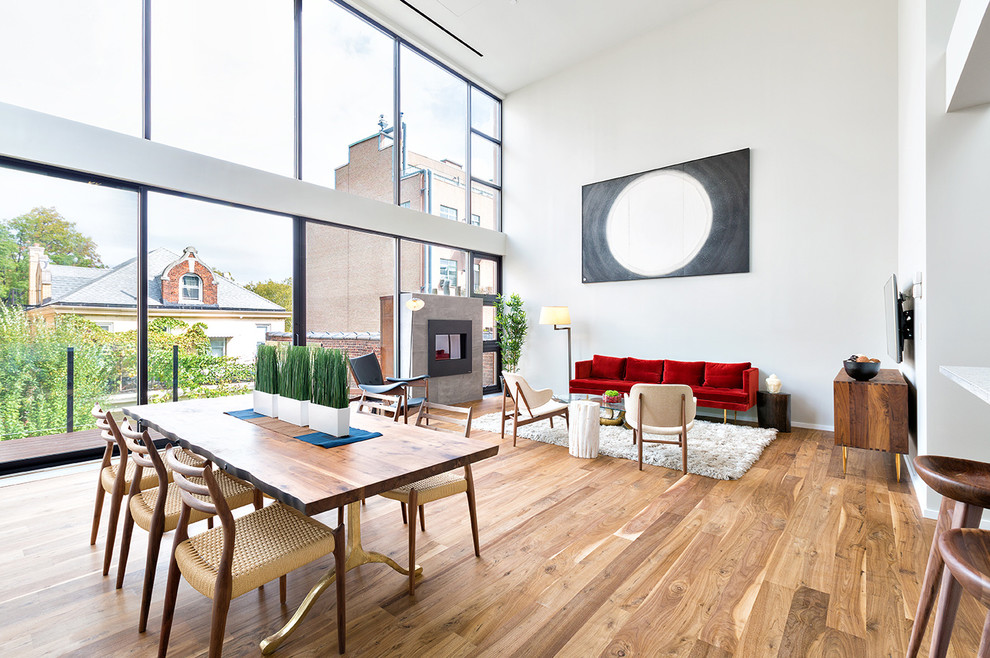 Foto di una sala da pranzo minimalista di medie dimensioni con pavimento in legno massello medio, camino classico e cornice del camino in pietra