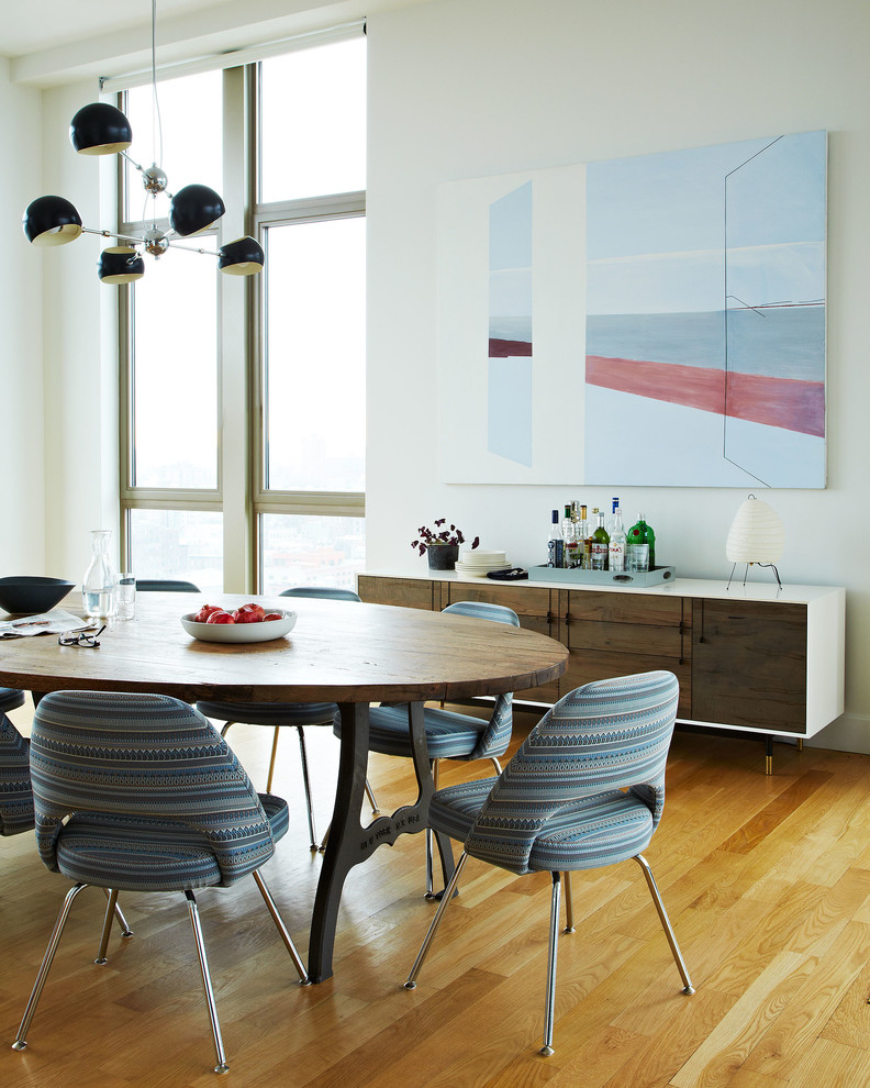 Dining room - scandinavian medium tone wood floor dining room idea in New York with white walls