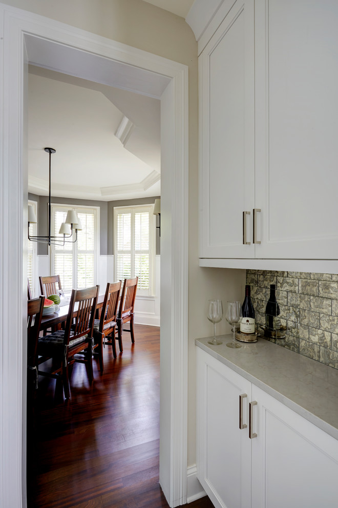 Источник вдохновения для домашнего уюта: отдельная столовая среднего размера в стиле неоклассика (современная классика) с серыми стенами, темным паркетным полом, двусторонним камином, фасадом камина из плитки и коричневым полом