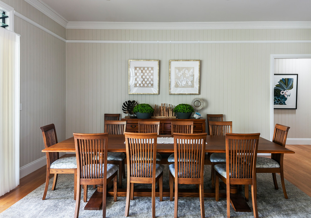 Foto di una grande sala da pranzo aperta verso il soggiorno bohémian con pareti bianche, parquet chiaro e pavimento arancione