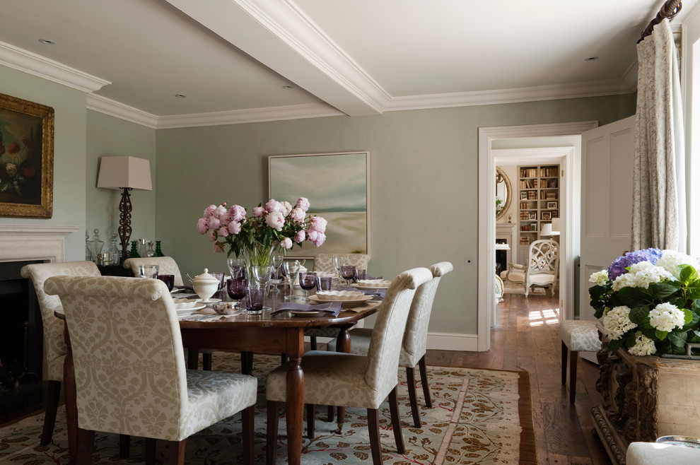Inspiration pour une salle à manger bohème avec un mur vert, un sol en bois brun et une cheminée standard.