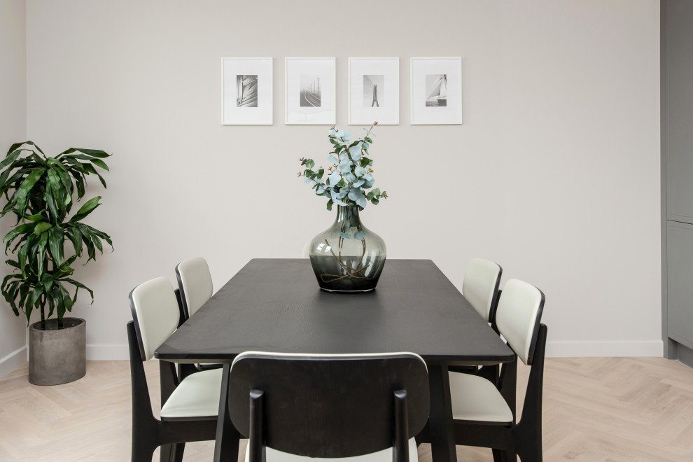 Cette photo montre une petite salle à manger ouverte sur la cuisine tendance avec un mur gris, parquet clair et un sol marron.