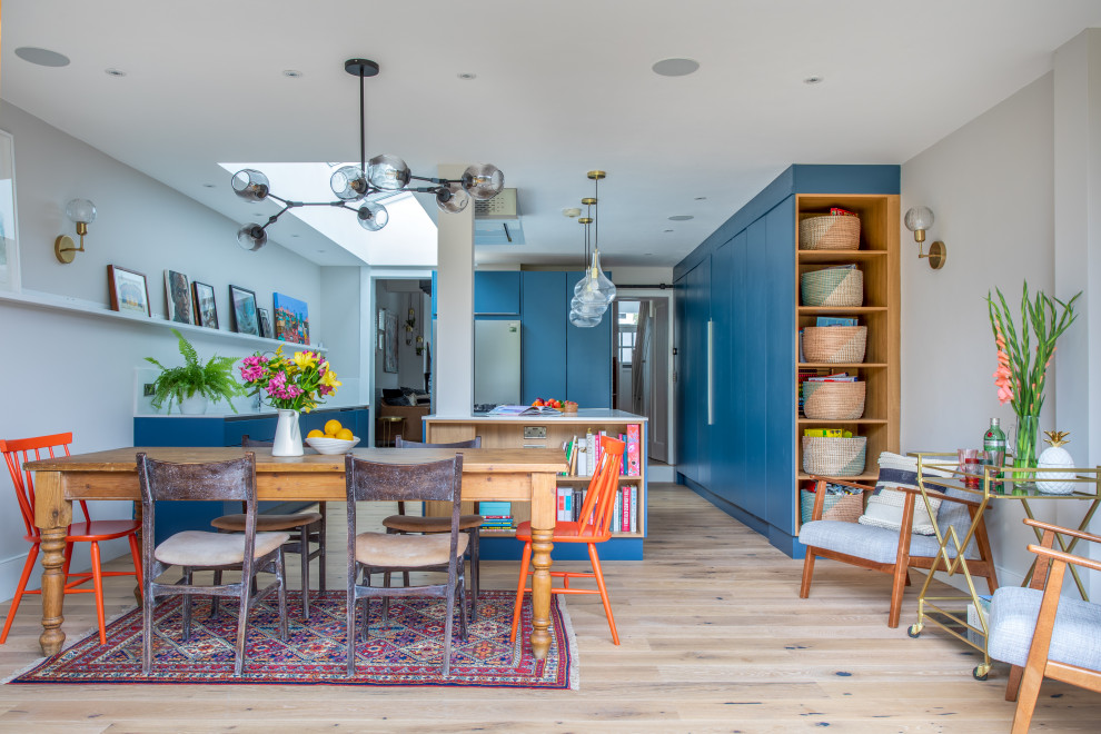 Große Moderne Wohnküche mit hellem Holzboden, weißer Wandfarbe und beigem Boden in London