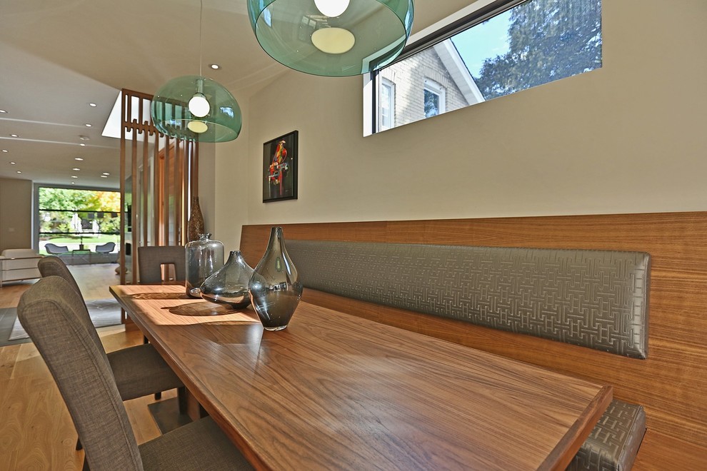 Exemple d'une salle à manger ouverte sur la cuisine moderne de taille moyenne avec un mur beige, un sol en bois brun, aucune cheminée et un sol marron.
