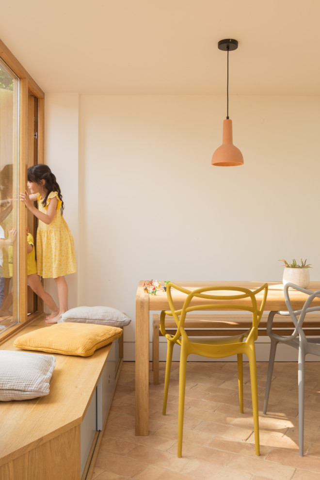 Свежая идея для дизайна: кухня-столовая среднего размера в современном стиле с белыми стенами, полом из терракотовой плитки и розовым полом - отличное фото интерьера