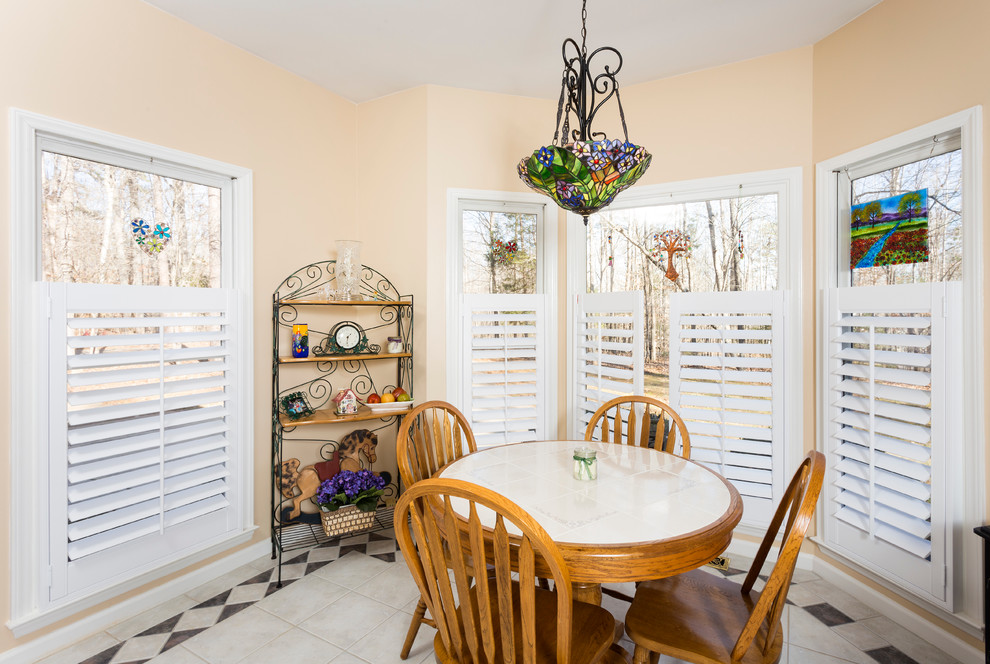 This is an example of a medium sized classic kitchen/dining room in Charlotte with beige walls, ceramic flooring, no fireplace and white floors.