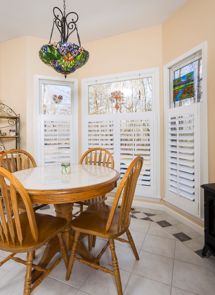 Immagine di una sala da pranzo aperta verso la cucina tradizionale di medie dimensioni con pareti beige, pavimento con piastrelle in ceramica, nessun camino e pavimento bianco