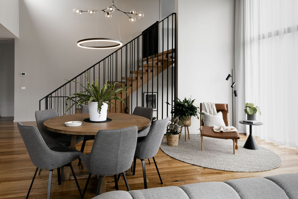 Inspiration pour une grande salle à manger ouverte sur le salon design avec un mur gris, parquet clair et un sol noir.