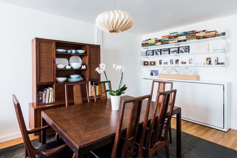 Photo of a medium sized scandinavian kitchen/dining room in New York with white walls, medium hardwood flooring and no fireplace.