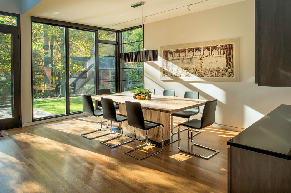 Ispirazione per una sala da pranzo design con pareti beige, pavimento in legno massello medio e pavimento marrone