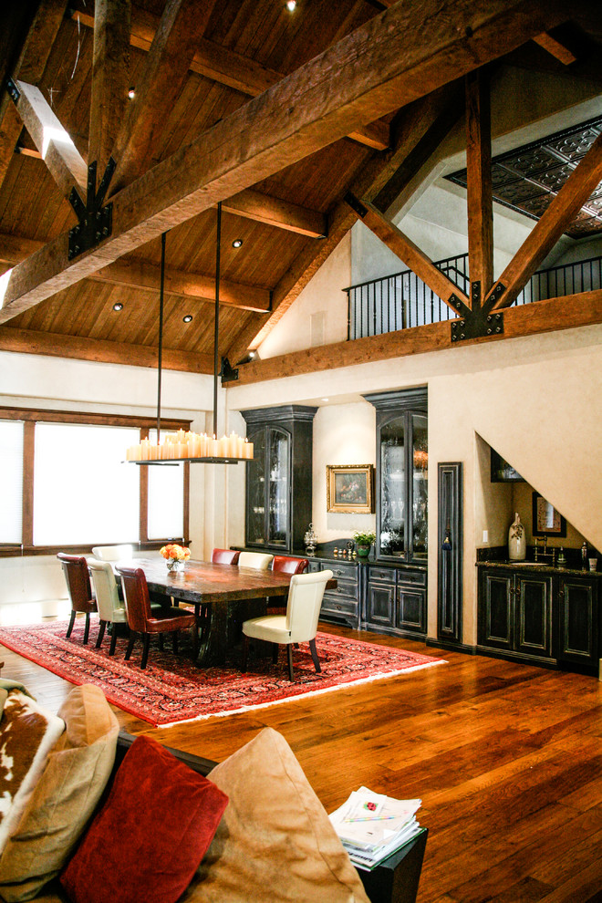 Aménagement d'une salle à manger ouverte sur le salon classique de taille moyenne avec un mur beige, un sol en bois brun, une cheminée standard, un manteau de cheminée en plâtre et un sol marron.