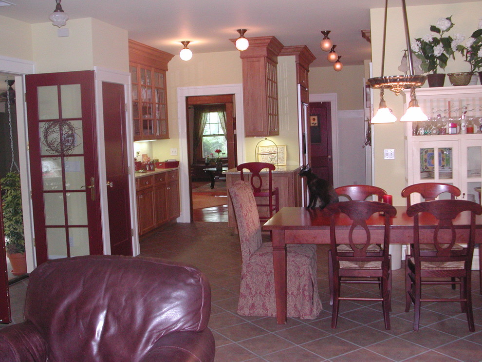 Foto di una sala da pranzo aperta verso il soggiorno american style di medie dimensioni con pareti gialle, pavimento in ardesia, nessun camino e pavimento marrone