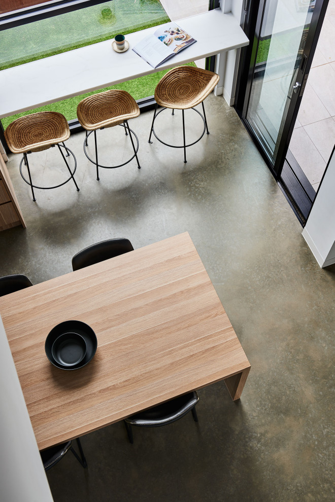 На фото: маленькая столовая в современном стиле с бетонным полом, серым полом, с кухонным уголком, белыми стенами и сводчатым потолком для на участке и в саду