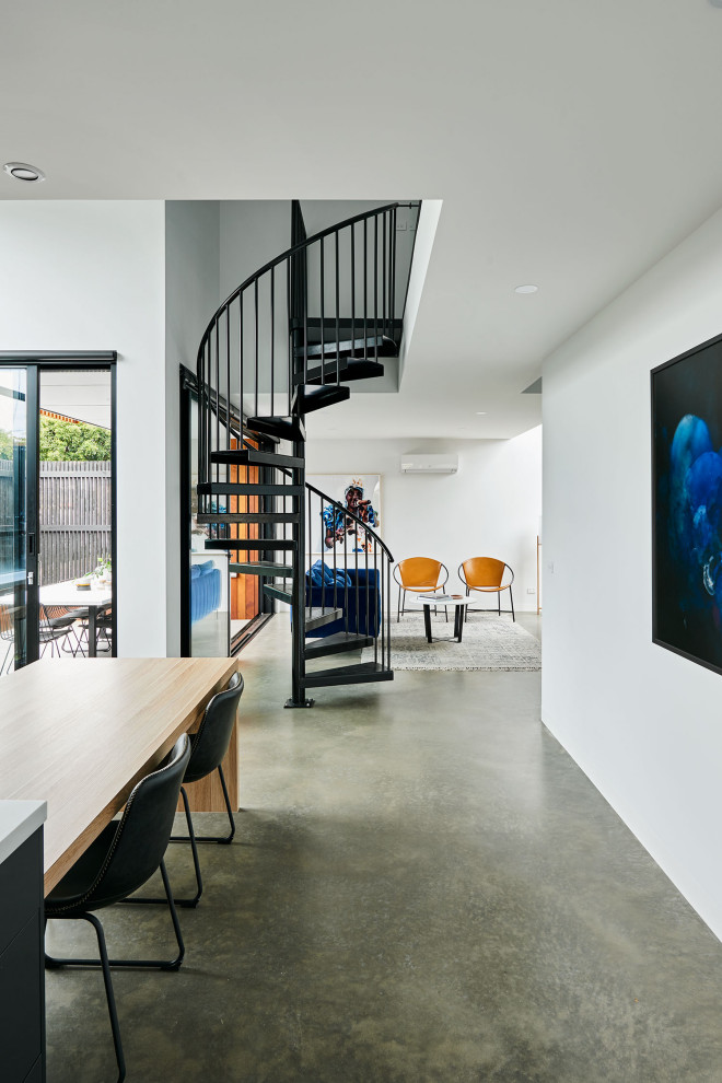 Esempio di una piccola sala da pranzo aperta verso la cucina design con pareti bianche, pavimento in cemento e pavimento grigio