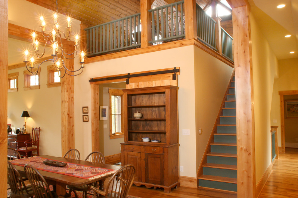 Idée de décoration pour une grande salle à manger ouverte sur le salon craftsman avec un mur blanc et un sol en bois brun.