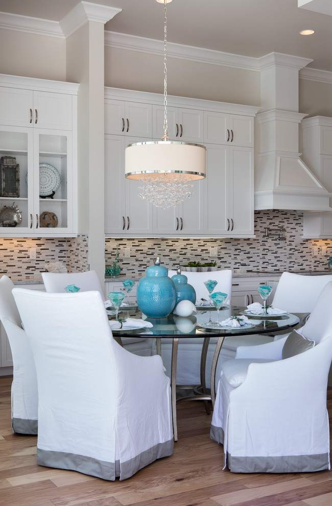 This is an example of a medium sized coastal kitchen/dining room in Miami with beige walls and light hardwood flooring.