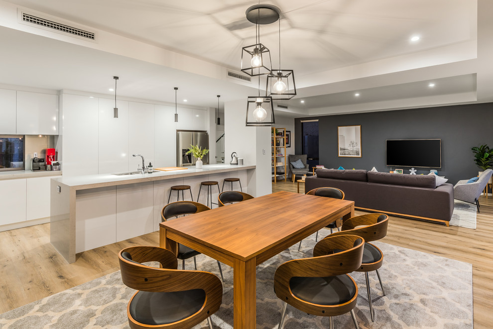 Cette image montre une salle à manger ouverte sur le salon design avec un mur gris, un sol en bois brun et un sol marron.