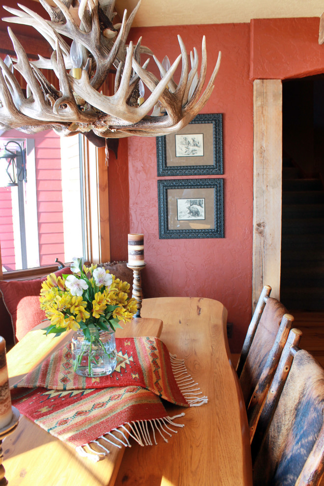 Immagine di una grande sala da pranzo aperta verso la cucina stile rurale con parquet chiaro, pareti rosse e nessun camino
