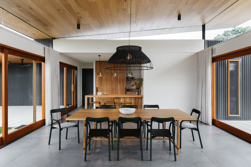 Immagine di una sala da pranzo aperta verso il soggiorno design con pareti bianche e pavimento grigio