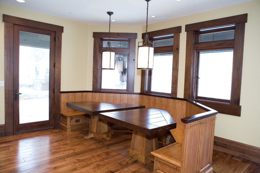 Exemple d'une grande salle à manger ouverte sur la cuisine montagne avec un mur beige et un sol en bois brun.