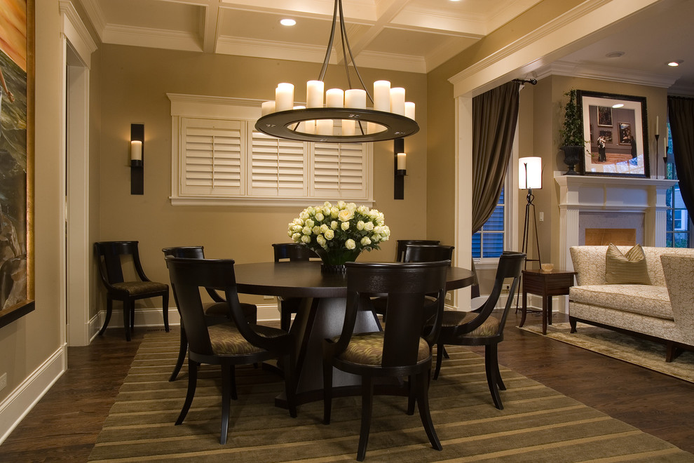 Aménagement d'une salle à manger classique avec parquet foncé, un mur beige, un sol marron et éclairage.