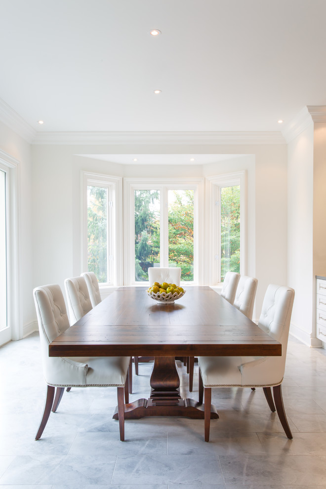 Photo of a traditional dining room in Toronto with white walls and grey floors.