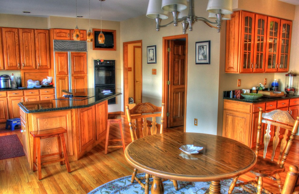 На фото: кухня-столовая среднего размера с желтыми стенами и паркетным полом среднего тона без камина с