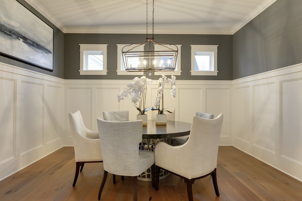 This is an example of a medium sized traditional enclosed dining room with grey walls, medium hardwood flooring and brown floors.