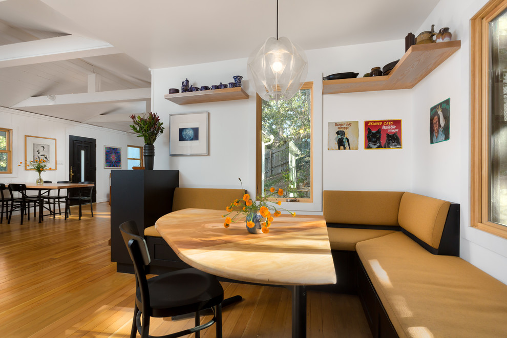Inspiration för en mellanstor minimalistisk matplats med öppen planlösning, med vita väggar, mellanmörkt trägolv och orange golv