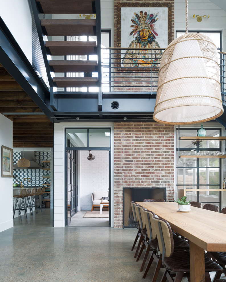 На фото: столовая среднего размера в стиле модернизм с бетонным полом, двусторонним камином, фасадом камина из кирпича и серым полом