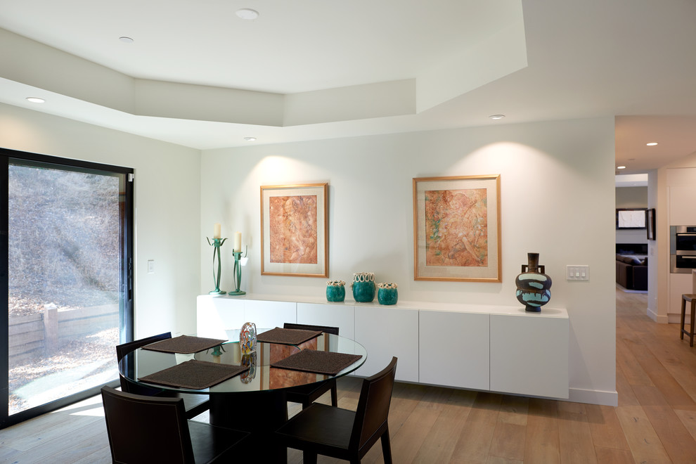Ispirazione per una sala da pranzo aperta verso la cucina contemporanea di medie dimensioni con pareti bianche, parquet chiaro, nessun camino e pavimento beige