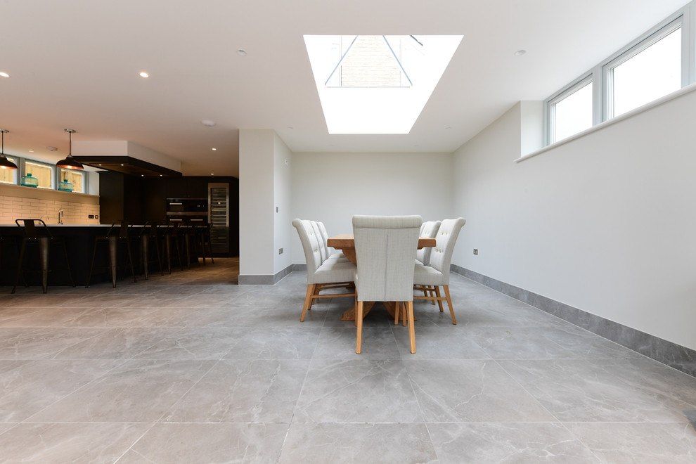 Aménagement d'une salle à manger contemporaine avec un sol en carrelage de porcelaine et un sol gris.