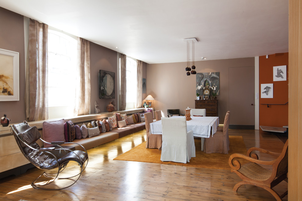 Cette photo montre une très grande salle à manger ouverte sur le salon éclectique avec un mur beige et un sol en bois brun.