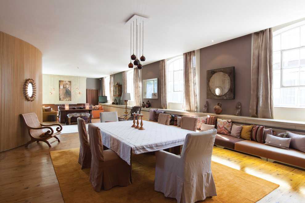 This is an example of an expansive eclectic open plan dining room in London with beige walls and medium hardwood flooring.